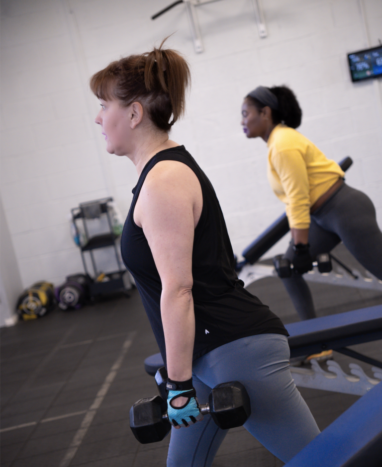 Sian, a 61-year-old gym member at The Training Gyms in Milton Keynes, smiling after a strength training session in a supportive, welcoming gym environment.