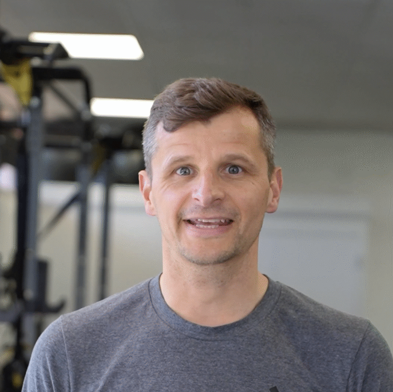 A gym member at The Training Gyms in Milton Keynes sharing his experience, standing in front of training equipment with a confident expression.